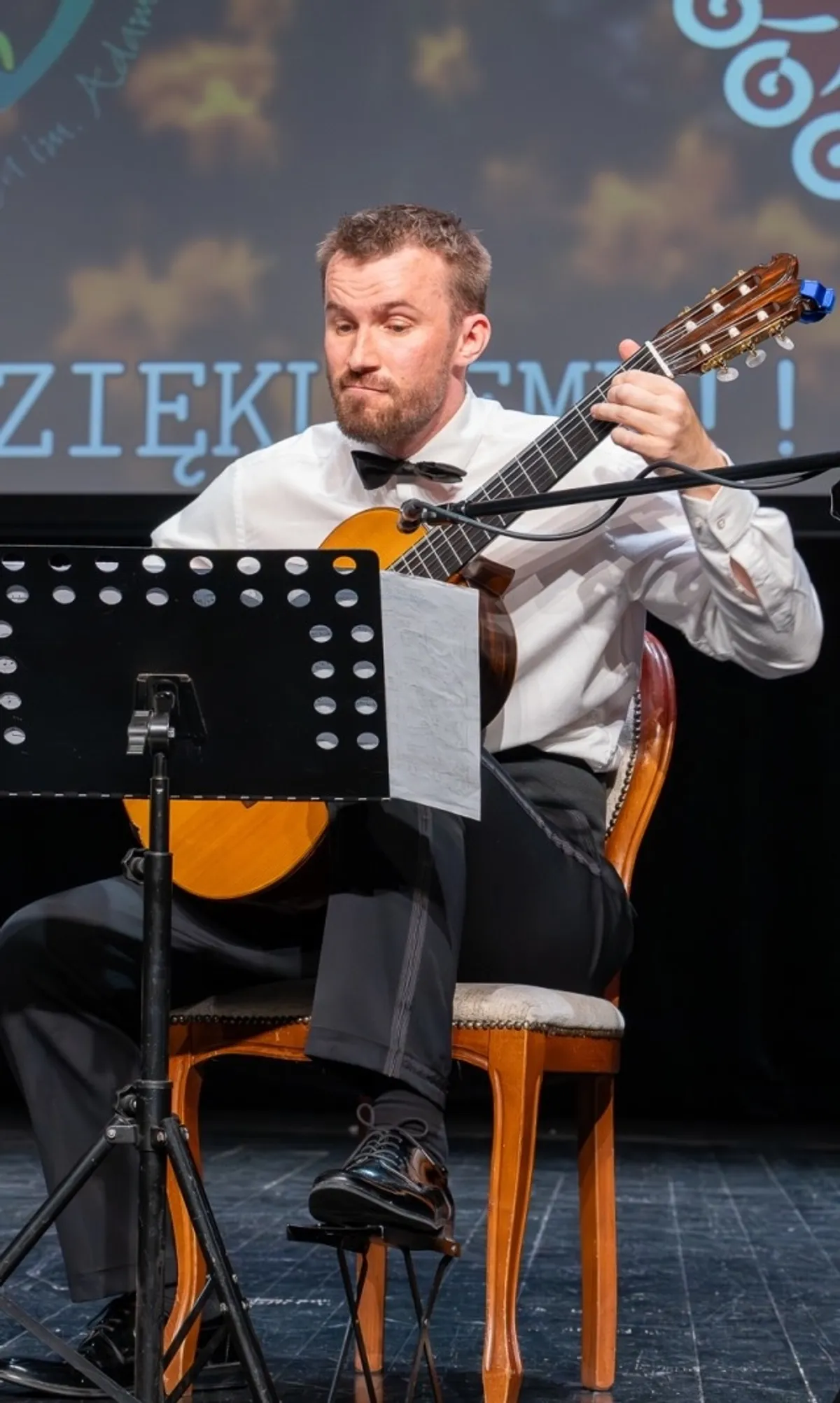 Tomasz Modranka podczas koncertu, grający na gitarze klasycznej